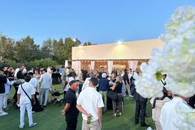 Assiette avec un jarret d'agneau en sauce et un millefeuille de légumes, servie sur une table dressée.