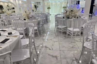 Assiette avec un jarret d'agneau en sauce et un millefeuille de légumes, servie sur une table dressée.