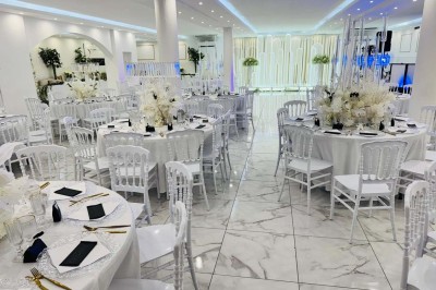 Assiette avec un jarret d'agneau en sauce et un millefeuille de légumes, servie sur une table dressée.
