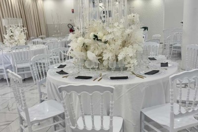 Assiette avec un jarret d'agneau en sauce et un millefeuille de légumes, servie sur une table dressée.