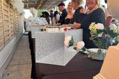 Assiette avec un jarret d'agneau en sauce et un millefeuille de légumes, servie sur une table dressée.