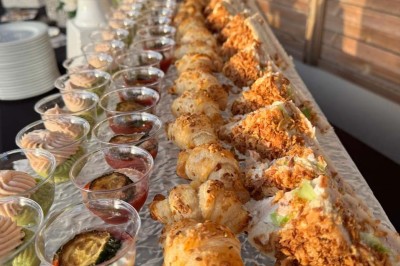 Assiette avec un jarret d'agneau en sauce et un millefeuille de légumes, servie sur une table dressée.