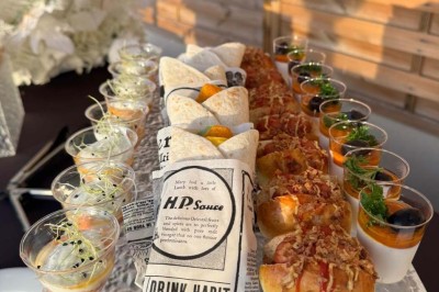 Assiette avec un jarret d'agneau en sauce et un millefeuille de légumes, servie sur une table dressée.