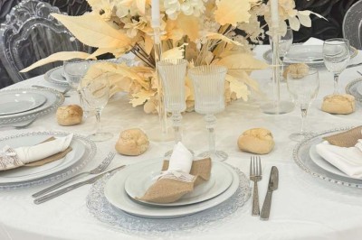 Assiette avec un jarret d'agneau en sauce et un millefeuille de légumes, servie sur une table dressée.