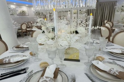 Assiette avec un jarret d'agneau en sauce et un millefeuille de légumes, servie sur une table dressée.