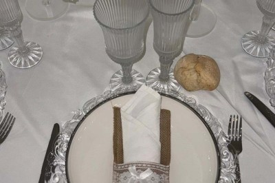 Assiette avec un jarret d'agneau en sauce et un millefeuille de légumes, servie sur une table dressée.