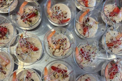 Assiette avec un jarret d'agneau en sauce et un millefeuille de légumes, servie sur une table dressée.