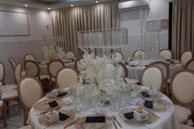 Assiette avec un jarret d'agneau en sauce et un millefeuille de légumes, servie sur une table dressée.