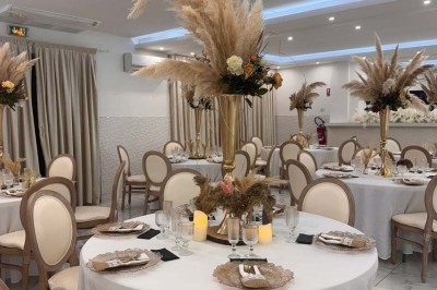 Assiette avec un jarret d'agneau en sauce et un millefeuille de légumes, servie sur une table dressée.