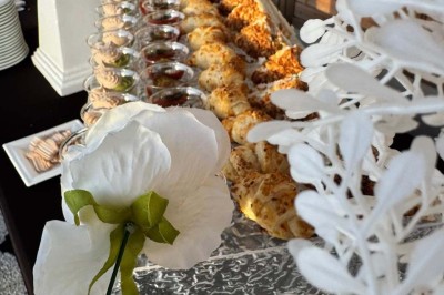 Assiette avec un jarret d'agneau en sauce et un millefeuille de légumes, servie sur une table dressée.