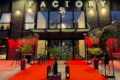 Salon avec canapé beige, table basse ronde, commode en bois sculpté et sol en carreaux décoratifs.