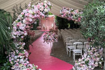 Salon avec canapé beige, table basse ronde, commode en bois sculpté et sol en carreaux décoratifs.