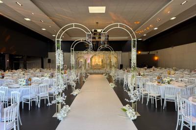 Salon avec canapé beige, table basse ronde, commode en bois sculpté et sol en carreaux décoratifs.