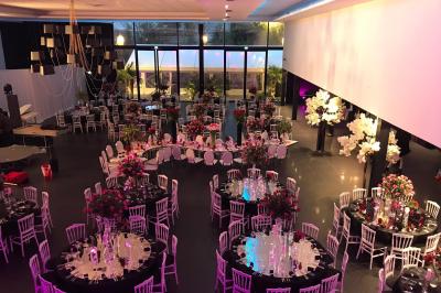 Salon avec canapé beige, table basse ronde, commode en bois sculpté et sol en carreaux décoratifs.