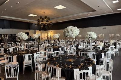 Salon avec canapé beige, table basse ronde, commode en bois sculpté et sol en carreaux décoratifs.