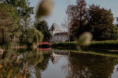 Miniature Location salle Léognan (Gironde) - Château Larrivet Haut-Brion #2 Vue sur une piscine extérieure entourée de pelouse, avec un lac et des arbres en arrière-plan sous un ciel dégagé.