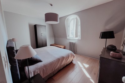 Miniature Chambre 4 Vue sur une piscine extérieure entourée de pelouse, avec un lac et des arbres en arrière-plan sous un ciel dégagé.