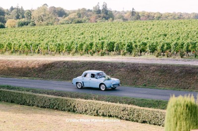 Table de réception élégamment dressée avec nappes blanches, verres, couverts, fleurs et bouteilles disposés harmonieusement.