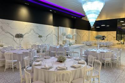 Couloir élégant avec tapis rouges, murs noirs brillants, éclairage bleu et lustre central en cristal.