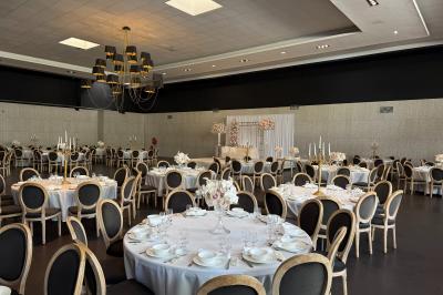 Couloir élégant avec tapis rouges, murs noirs brillants, éclairage bleu et lustre central en cristal.