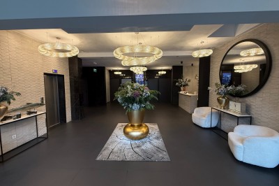 Miniature Accueil Square Salle de conférence moderne avec des rangées de chaises noires, sol en marbre et toit vitré laissant entrer la lumière…