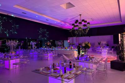 Miniature Soirée square Salle de conférence moderne avec des rangées de chaises noires, sol en marbre et toit vitré laissant entrer la lumière…