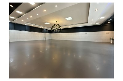 Miniature Square Salle de conférence moderne avec des rangées de chaises noires, sol en marbre et toit vitré laissant entrer la lumière…