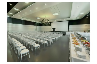 Miniature Square séminaire Salle de conférence moderne avec des rangées de chaises noires, sol en marbre et toit vitré laissant entrer la lumière…