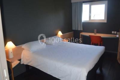 Salon moderne avec canapé, fauteuils en rotin, table basse en verre, décoration minimaliste et murs neutres.