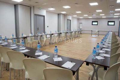 Salon moderne avec canapé, fauteuils en rotin, table basse en verre, décoration minimaliste et murs neutres.