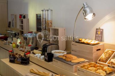 Salon moderne avec canapé, fauteuils en rotin, table basse en verre, décoration minimaliste et murs neutres.