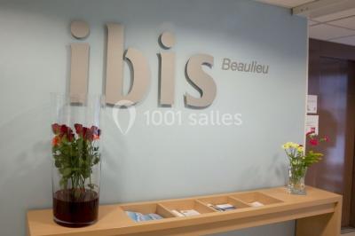 Salon moderne avec canapé, fauteuils en rotin, table basse en verre, décoration minimaliste et murs neutres.