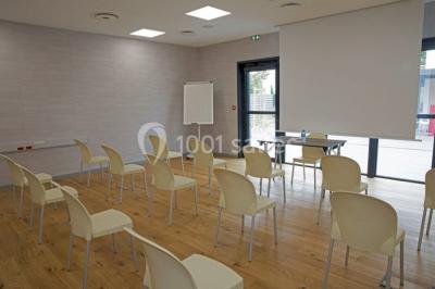 Salon moderne avec canapé, fauteuils en rotin, table basse en verre, décoration minimaliste et murs neutres.