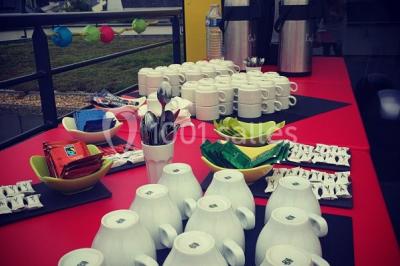 Salon moderne avec canapé, fauteuils en rotin, table basse en verre, décoration minimaliste et murs neutres.