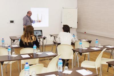 Salon moderne avec canapé, fauteuils en rotin, table basse en verre, décoration minimaliste et murs neutres.