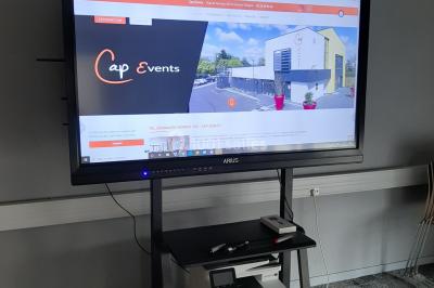 Salon moderne avec canapé, fauteuils en rotin, table basse en verre, décoration minimaliste et murs neutres.