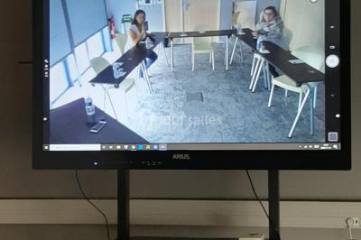 Salon moderne avec canapé, fauteuils en rotin, table basse en verre, décoration minimaliste et murs neutres.