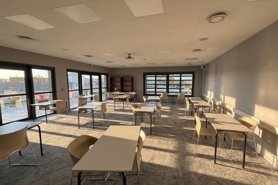 Écran interactif affichant le site web d'une salle événementielle, posé sur un support avec une imprimante en dessous.
