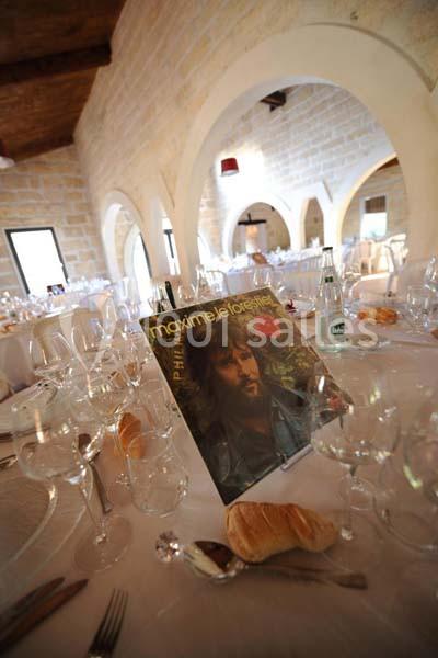 Photo d'une salle de réception avec des tables dressées et un disque vinyle de Maxime Le Forestier en décoration.