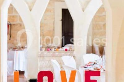 Des musiciens en tenue blanche et rayée jouent des percussions en extérieur, près d'une petite fille.