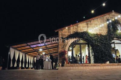 Des musiciens en tenue blanche et rayée jouent des percussions en extérieur, près d'une petite fille.