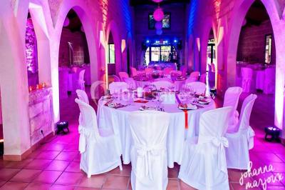 Des musiciens en tenue blanche et rayée jouent des percussions en extérieur, près d'une petite fille.