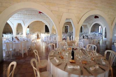 Des musiciens en tenue blanche et rayée jouent des percussions en extérieur, près d'une petite fille.