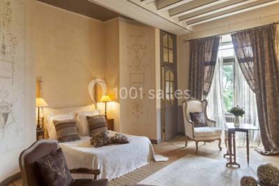 Piscine extérieure avec transats et parasols, entourée de verdure et située près d'une maison en pierre.