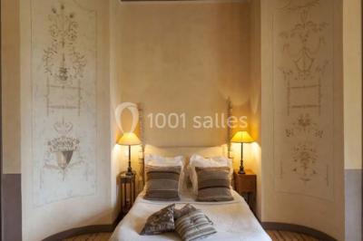 Piscine extérieure avec transats et parasols, entourée de verdure et située près d'une maison en pierre.