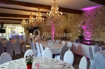 Piscine extérieure avec transats et parasols, entourée de verdure et située près d'une maison en pierre.