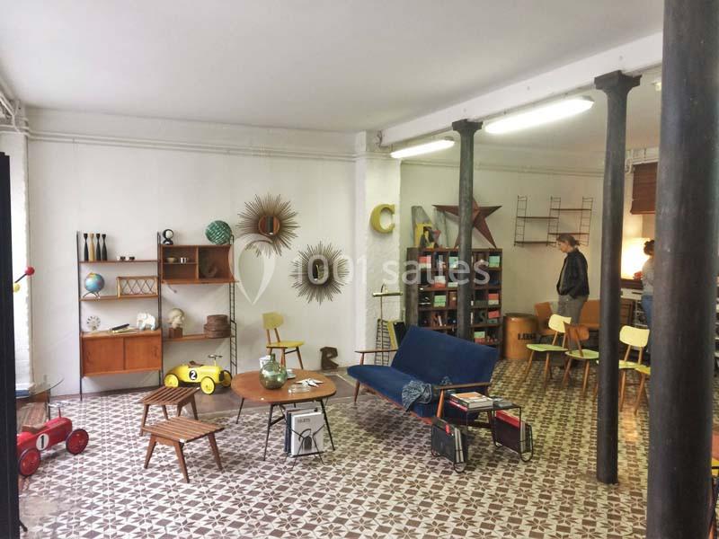 Salle aménagée avec des meubles vintage, des jouets anciens et une décoration rétro sur un sol en carreaux géométriques.