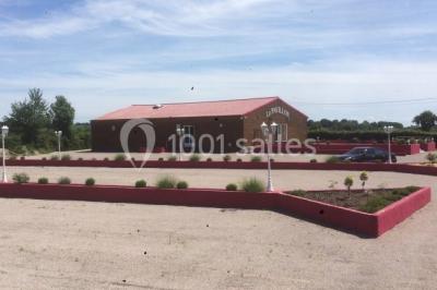 Parking extérieur rempli de voitures, avec un homme debout près d'une Audi noire sous un ciel dégagé.