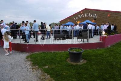 Parking extérieur rempli de voitures, avec un homme debout près d'une Audi noire sous un ciel dégagé.