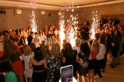 Parking extérieur rempli de voitures, avec un homme debout près d'une Audi noire sous un ciel dégagé.